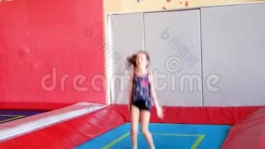 小女孩在蹦床上蹦极，在游戏中心蹦极。